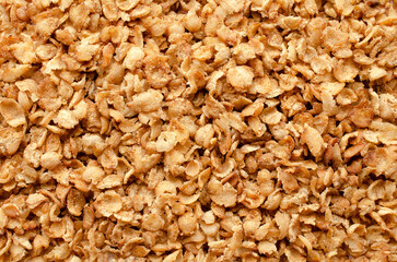 Close-up buckwheat flakes background, texture, top view. Buckwheat flakes a background, top view. A bunch of healthy buckwheat flakes. Top view of buckwheat flakes, background, texture, healthy food.
