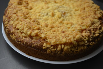 Kitchen, delicious homemade pie with pumpkin and apricot pieces placed on a white plate.