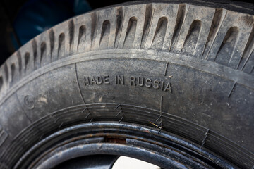 A fragment of a truck wheel tread with the inscription “Made in Russia” close-up.