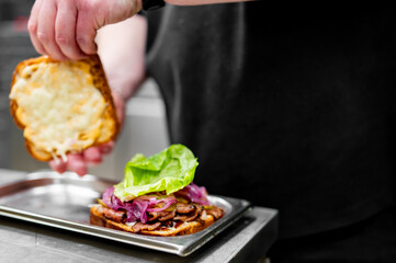 gourmet sandwich meticulously assembled by a chef, showcasing culinary artistry and vibrant colors...