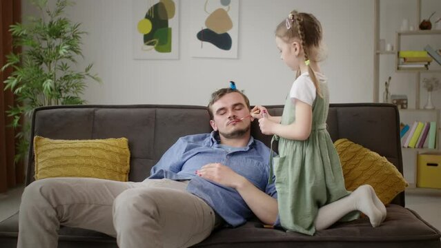 Relaxed Father Gets a Makeover from His Young Daughter with Lipstick and Hair Clips