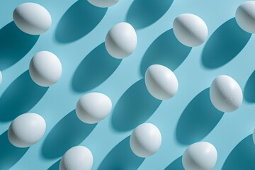 Pattern of white eggs on blue surface with shadows casted over them