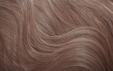 Blond hair close-up as a background. Women's long light brown hair. Beautifully styled wavy shiny...