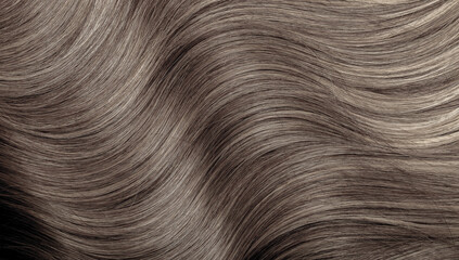 Brown hair close-up as a background. Women's long brown hair. Beautifully styled wavy shiny curls....