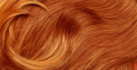 Red hair close-up as a background. Women's long orange hair. Beautifully styled wavy shiny curls....