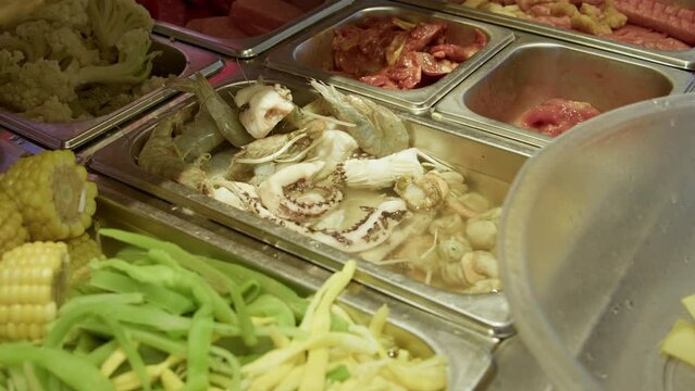 Graded UHD closeup shot of the delicious Chinese food. Choosing ingredients for delicious Malatang hot pot. Filmed as 6k RAW.