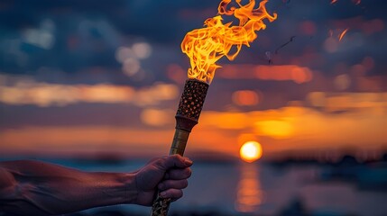Close-up of a lighted Olympic torch at sunset - obrazy, fototapety, plakaty