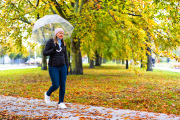 Healthy lifestyle - mid-adult woman walking in city park holding umbrella
- 765606040