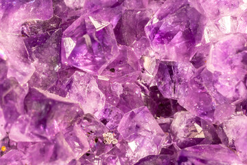 Amethyst purple crystals. Gems. Mineral crystals in the natural environment. Texture of precious and semiprecious stones. Seamless background with copy space colored shiny surface of precious stones.