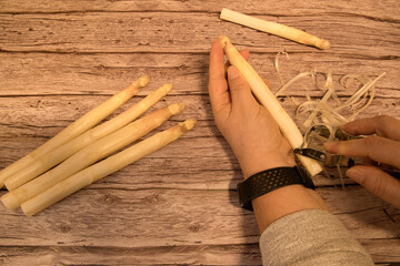 a woman's hand peels white asparagus