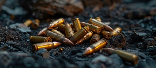 A collection of bullet shells resting atop a mound of dirt, showing evidence of firearm use.