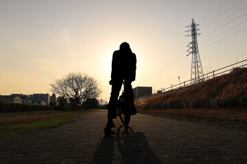 Silhouette man riding a bycicle with beautiful sunset