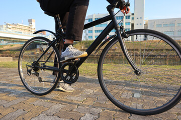 Half-body shot of A young man riding a bike. cycling outdoors, close up of the feet on pedal - obrazy, fototapety, plakaty