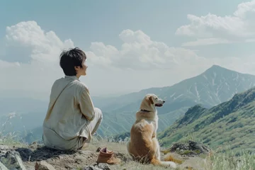 Fotobehang a teenager and a dog sit on a mountainside and look into the distance © SERGEY