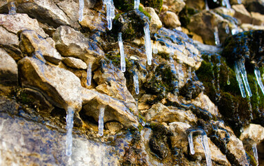 Icicles, ice on a rocky, rocky slope. The concept of global climate, warming, nature.