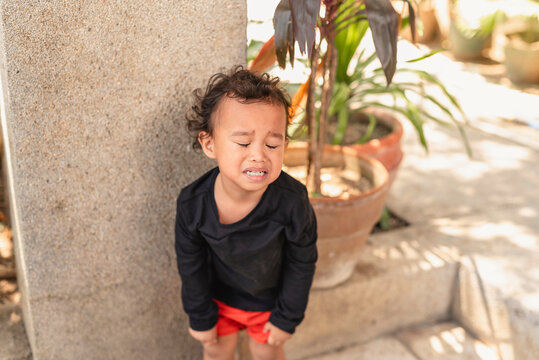 Upset Asian toddler boy crying during a tantrum outdoors