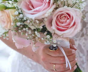 Bride holds a bridal bouquet with pink roses
