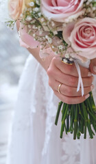 Bride holds a bridal bouquet with pink roses