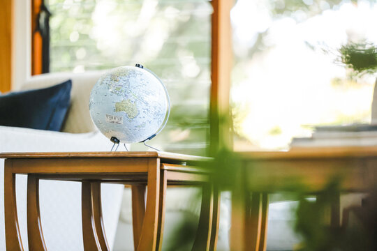 3D jigsaw puzzle of the Earth. Globe in well-lit living area on bright spring day.