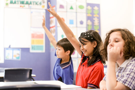 Three Students in the classroom sitting at their desk