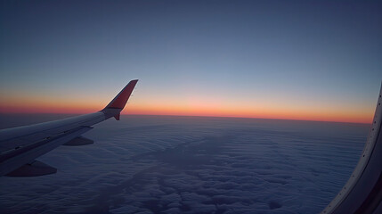 Fototapeta premium Wing of an airplane with sunset horizon over clouds.
