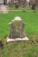 An old stone grave with a blank anonymouse epitaph.