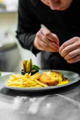 A chef adding the final garnish to a beautifully presented dish, showcasing the art and precision involved in culinary presentation