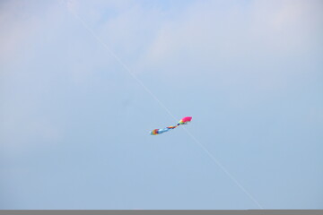 Colorful kites flying in the clear blue sky in sunny summer day at Mekong Delta Vietnam. Happy childhood moments.