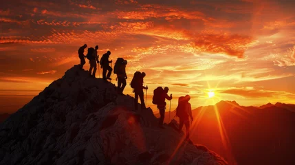 Rucksack A team of climbers reaching the summit at sunrise silhouetted against the fiery sky © JR-50