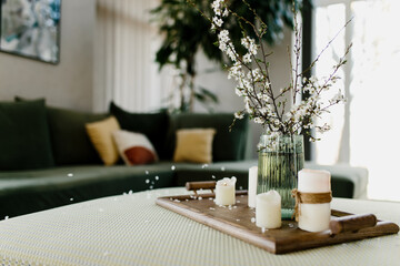 Home interior. Relaxing candles. Apple tree color has flown. Blurred background