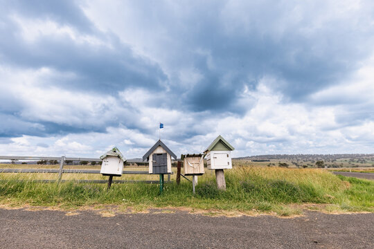Rustic roadside mailboxes in remote area of country New South Wales with Australian flag flying