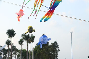 Colorful kites flying in the clear blue sky in sunny summer day at Mekong Delta Vietnam. Happy...