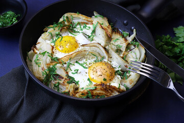 Uova fritte fatte in casa e finocchio con erbe in una padella di ferro su sfondo grigio. Cibo sano e vegetariano. Vista dall'alto. - 765649082
