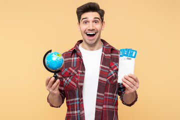 Excited man, holding globe and plane tickets, eyes wide open in surprise, thrilled adventure winner