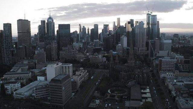 Aerial Backward Shot Of Roman Catholic Archdiocese In Modern City Under Cloudy Sky - Melbourne, Australia