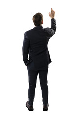 A man in business attire is seen from behind, reaching out as if pressing a virtual button,...