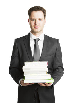 A young businessman in formal attire holding a stack of books, isolated on a white background, depicting the concept of research and knowledge