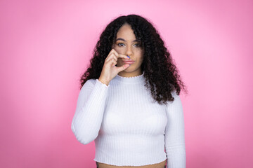 African american woman wearing casual sweater over pink background mouth and lips shut as zip with...