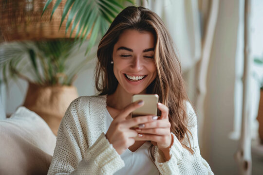 Happy woman smiling using phone in a cozy room