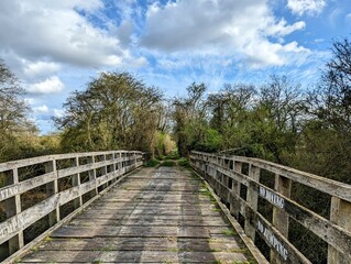 View along an old wooden single track bridge with the warning 