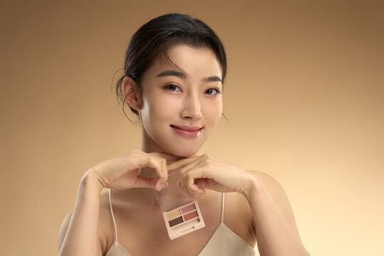 Young beauty with eye shadow box
