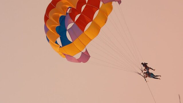 Parasailers Flying On Colorful Parachute In Sunset Or Sunrise Sky. Active Hobby.