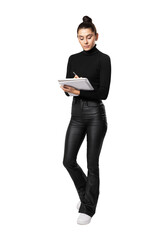 A young woman in a black outfit writing in a notebook, isolated on a white background, depicting a concept of education or business