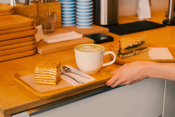 mug of coffee with a piece of cake on a tray. Morning breakfast