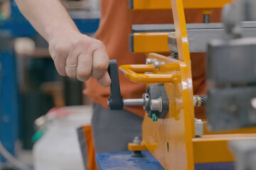 A worker turns a lever on machine. The plant is in production.