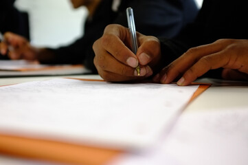 Child's holding a pen writing on paper