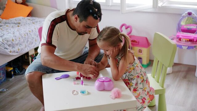 Daughter and father role-playing manicure salon