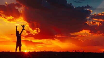 A lone soccer player silhouetted against a dramatic sunset, triumphantly holding the championship trophy aloft. Evoke a sense of victory and achievement.