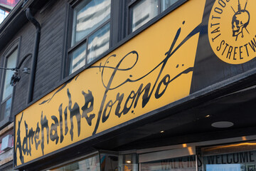 Fototapeta premium sign outside Adrenaline Tattoos located at 239 Queen Street West in Toronto, Canada