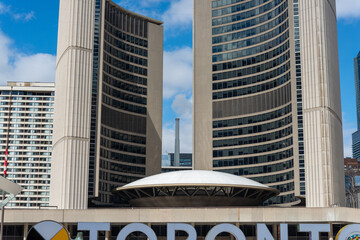 Fototapeta premium part of the iconic city name sign and New City Hall at Nathan Phillips Square in Toronto, Canada